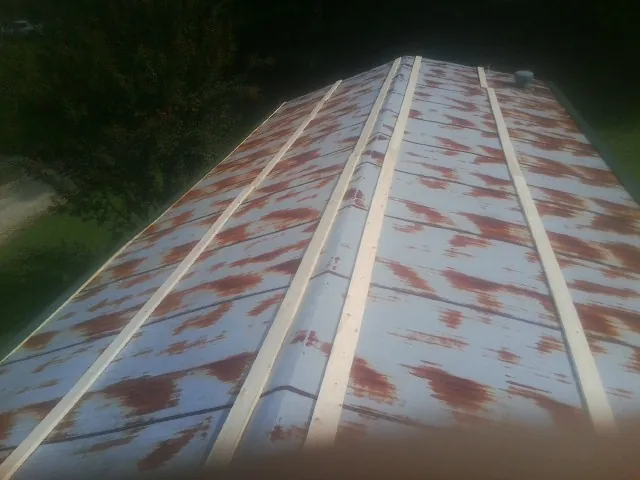 Rusted metal roof panels with new wood purlins before replacement — Storm Damage Roof Repair in Hamptonville by Roofing Brothers