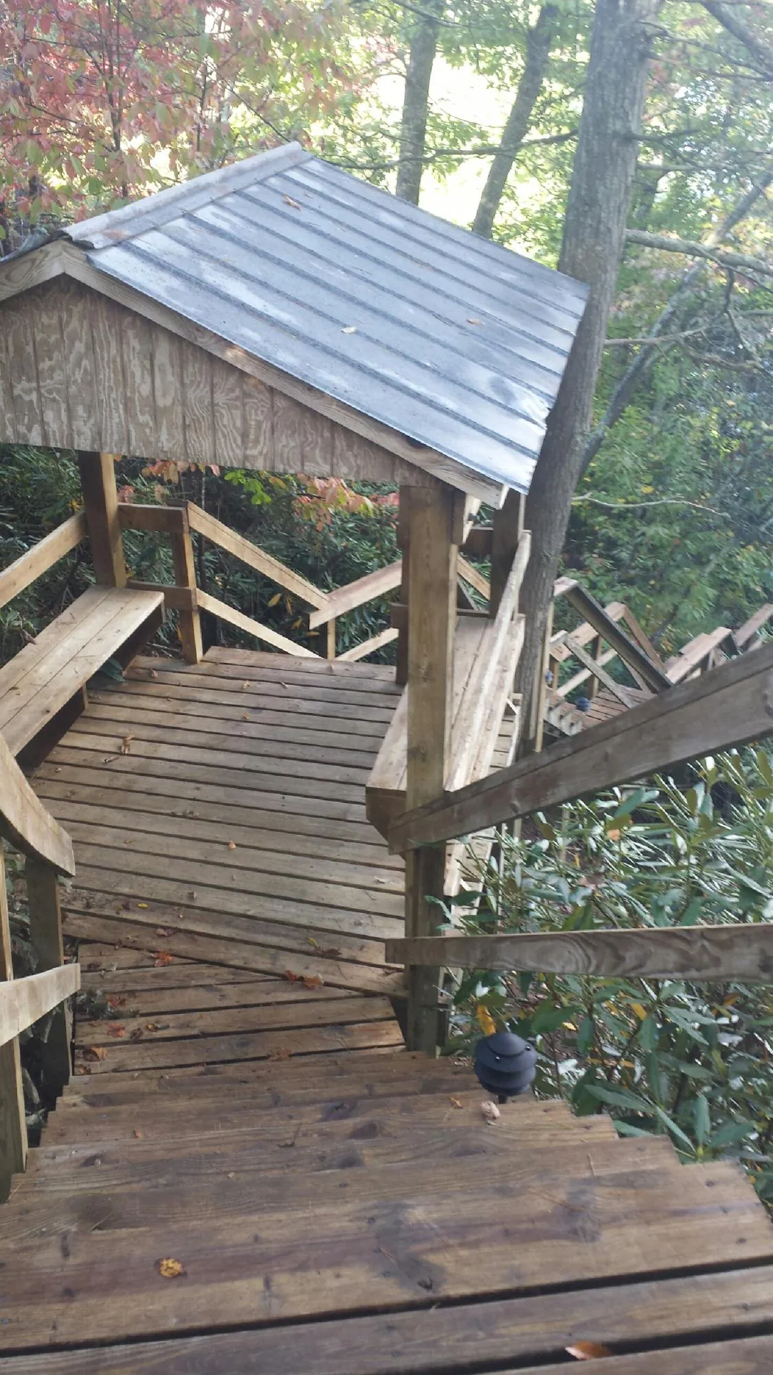 Metal roofed shelter over wooden steps on a wooded walkway — Skylight Repair & Installation work by our crew in Hamptonville
