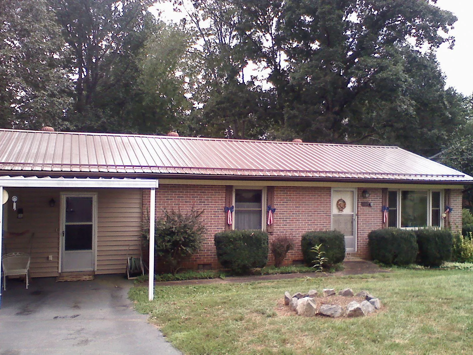 Bronze metal roof and carport on a brick ranch home — Roof Repair work by our crew in Hamptonville